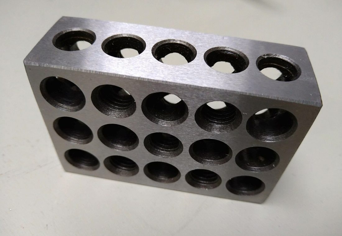123 block: A 1 x 2 x 3 inch precision steel block commonly used as a square reference or mount point when milling. Often comprised of blank holes or taped screw holes to add objects to be firmly bolted to it.