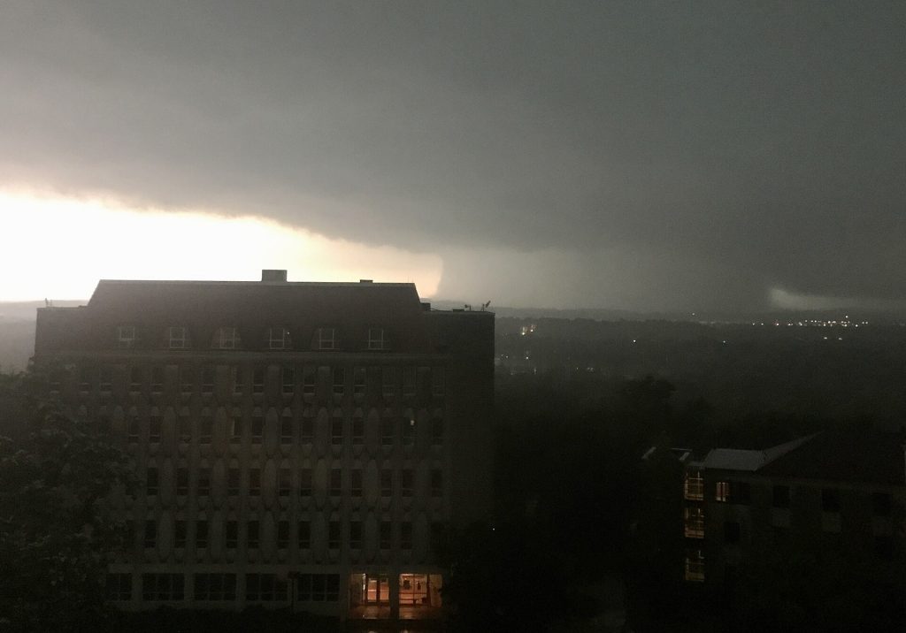 This photo was taken using an iPhone looking south out of a window in the stairwell of Fraser Hall at the University of Kansas in Lawrence. It shows Blake Hall with a rain-sheathed tornado vortex in the background. The tornado was ultimately rated as low-end EF4 on the Enhanced Fujita scale, with estimated winds of 170 mph (270 km/h), though a storm chasing research team found winds of 190 mph (310 km/h) from a rocket probe. The tornado caused $48 million USD in total damages within Douglas and Leavenworth Counties, with areas in the vicinity or within southeastern Lawrence and Linwood taking the worst damage.