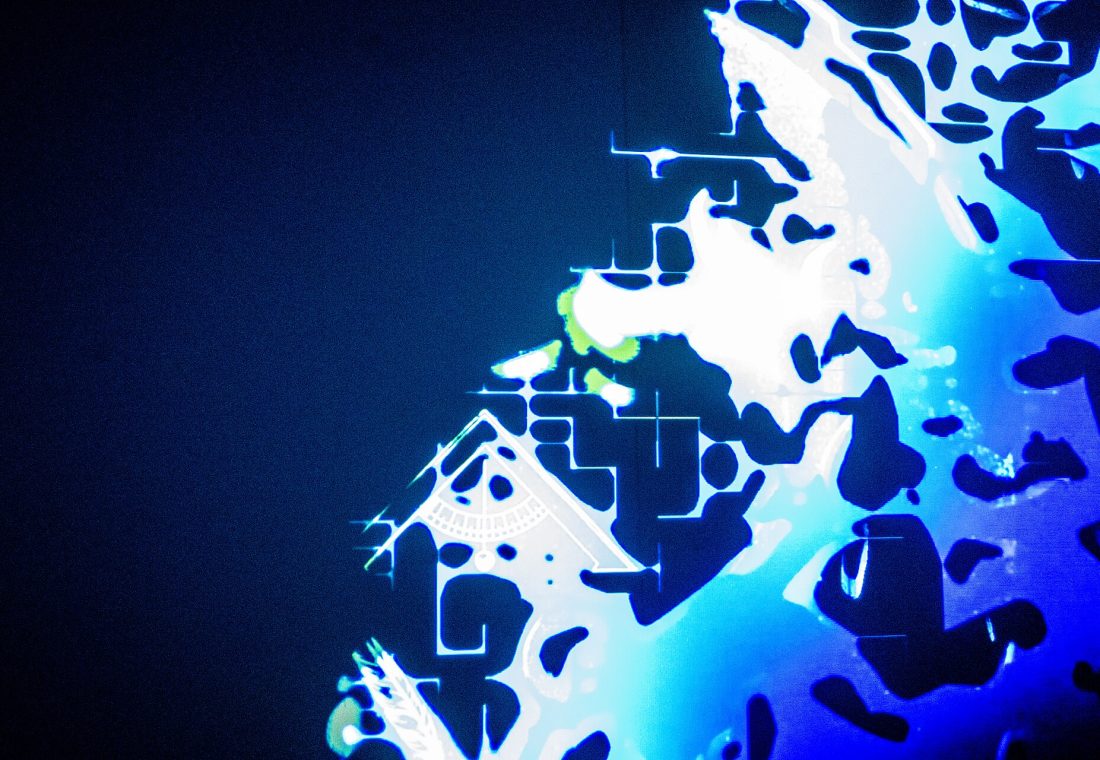 A close-up, abstract view of a digital pattern resembling a neural network or cellular structure, with bright white and blue light against a dark teal background.