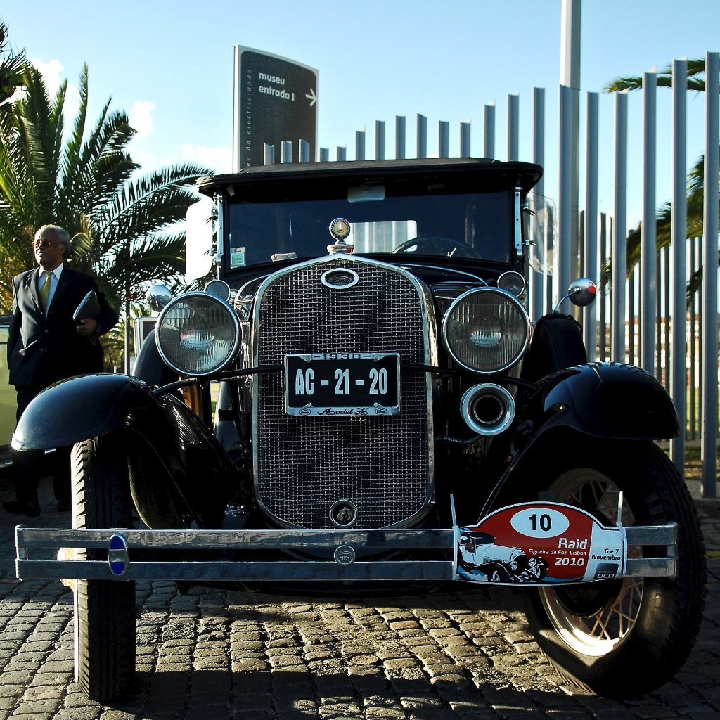 Belem, Lisbon, Portugal HISTORY OVERVIEW ManufacturerFord Motor Company Production1927–1931 AssemblyChester, Pennsylvania Chicago, Illinois Dearborn, Michigan Jacksonville, Florida Long Beach, California San Francisco, California Saint Paul, Minnesota Windsor, Ontario Buenos Aires, Argentina Santiago, Chile Cologne, Germany Yokohama, Japan Copenhagen, Denmark Cork, Ireland Trafford Park, England Geelong, Victoria Nizhny Novgorod, Russia BODY AND CHASSIS class full-size Ford Body style – Chassis POWERTRAIN Engine201 CID (3.3 L) L-head I4 Transmission3-speed sliding gear manual Dimensions Wheelbase103.5 in (2,629 mm)[1] Length165 in (4,191 mm) Width67 in (1,702 mm) Curb weight2,265 lb (1,027 kg) CHRONOLOGY PredecessorFord Model T SuccessorFord Model B The Ford Model A (also colloquially called the A-Model Ford or the A, and A-bone among rodders and customizers) was the Ford Motor Company's second market success after its predecessor, the Model T. First produced on October 20, 1927, but not introduced until December 2, it replaced the venerable Model T, which had been produced for 18 years. This new Model A (a previous model had used the name in 1903–04) was designated a 1928 model and was available in four standard colors. By February 4, 1929, one million Model As had been sold, and by July 24, two million. The range of body styles ran from the Tudor at US$500 (in grey, green, or black) to the Town Car with a dual cowl at US$1200. In March 1930, Model A sales hit three million, and there were nine body styles available. Model A production ended in March 1932, after 4,858,644 had been made in all body styles. Its successor was the Model B, which featured an updated inline four-cylinder engine, as well as the Model 18, which introduced Ford's new flathead (side-valve) V8 engine. FEATURES Prices for the Model A ranged from US$385 for a roadster to US$1400 for the top-of-the-line Town Car. The engine was a water-cooled L-head inline-four with a displacement of 201 cu in (3.3 l). This engine provided 40 hp (30 kW; 41 PS).[7] Top speed was around 65 mph (105 km/h). The Model A had a 103.5 in (2,630 mm) wheelbase with a final drive ratio of 3.77:1. The transmission was a conventional unsynchronized three-speed sliding gear manual with a single-speed reverse. The Model A had four-wheel mechanical drum brakes. The 1930 and 1931 models were available with stainless steel radiator cowling and headlamp housings. The Model A came in a wide variety of styles including a Coupe (Standard and Deluxe), Business Coupe, Sport Coupe, Roadster Coupe (Standard and Deluxe), Convertible Cabriolet, Convertible Sedan, Phaeton (Standard and Deluxe), Tudor Sedan (Standard and Deluxe), Town Car, Fordor (five-window standard, three-window deluxe), Victoria, Town Sedan, Station Wagon, Taxicab, Truck, and Commercial.[citation needed] The very rare Special Coupe started production around March 1928 and ended mid-1929. The Model A was the first Ford to use the standard set of driver controls with conventional clutch and brake pedals, throttle, and gearshift. Previous Fords used controls that had become uncommon to drivers of other makes. The Model A's fuel tank was situated in the cowl, between the engine compartment's firewall and the dash panel. It had a visual fuel gauge, and the fuel flowed to the carburettor by gravity. A rear-view mirror was optional. In cooler climates, owners could purchase an aftermarket cast iron unit to place over the exhaust manifold to provide heat to the cab. A small door provided adjustment of the amount of hot air entering the cab. The Model A was the first car to have safety glass in the windshield. The Soviet company GAZ, which started as a joint venture between Ford and the Soviet Union, made a licensed version from 1932–1936. This served as the basis for the FAI and BA-20 armoured cars which saw use as Soviet scout vehicles in the early stages of World War II. In addition to the United States, Ford made the Model A in plants in Argentina, Canada, Denmark, France, Germany, Japan and the United Kingdom. In Europe, where in some countries cars were taxed according to engine size, Ford in the UK manufactured the Model A with a smaller displacement engine of 2,043 ccs (124.7 cu in), providing a claimed output of 28 hp (21 kW; 28 PS).[ However, this equated to a British fiscal horsepower of 14.9 hp (11.1 kW; 15.1 PS) (compared to the 24 hp (18 kW; 24 PS) of the larger engine) and attracted a punitive annual car tax levy of £1 per fiscal hp in the UK. It, therefore, was expensive to own and too heavy and uneconomical to achieve volume sales, and so unable to compete in the newly developing mass market, while also too crude to compete as a luxury product. European manufactured Model As failed to achieve the sales success in Europe that would greet their smaller successor in England and Germany. DEVELOPMENT HISTORY From the mid 1910s through the early 1920s, Ford dominated the automotive market with its Model T. However, during the mid-1920s, this dominance eroded as competitors, especially the various General Motors divisions, caught up with Ford's mass production system and began to better Ford in some areas, especially by offering more powerful engines, new convenience features, or cosmetic customization. Also, features Henry Ford considered to be unnecessary, such as electric starters, were gradually shifting in the public's perception from luxuries to essentials. Ford's sales force recognized the threat and advised Henry to respond to it. Initially, he resisted, but the T's sagging market share finally forced him to admit a replacement was needed. When he finally agreed to begin development of this new model, he focused on the mechanical aspects and on what today is called design for manufacturability (DFM), which he had always strongly embraced and for which the Model T production system was famous. Although ultimately successful, the development of the Model A included many problems that had to be resolved. For example, the die stamping of parts from sheet steel, which the Ford company had led to new heights of development with the Model T production system, was something Henry had always been ambivalent about; it had brought success, but he felt that it was not the best choice for durability. He was determined that the Model A would rely more on drop forgings than the Model T, but his ideas to improve the DFM of forging did not prove practical. Eventually, Ford's engineers persuaded him to relent, lest the Model A's production cost force up its retail price too much. Henry's disdain for cosmetic vanity as applied to automobiles led him to leave the Model A's styling to a team led by his son Edsel, even though he would take credit for it despite his son doing more of the work. It was during the period from the mid-1920s to early 1930s that the limits of the first generation of mass production, epitomized by the Model T production system's rigidity, became apparent. The era of "flexible mass production" had begun. FILM AND MEDIA The Model A was well represented in media of the era since it was one of the most common cars. Model kits remain available from hobby shops as stock cars or hot rods. Several Model As have obtained particular fame. The "Mean Green Machine", a green and black 1931 Tudor Sedan, has been a staple of University of North Texas football games and special events since 1974, maintained by the spirit organization Talons since the 1980s. The Ramblin' Wreck, a 1930 Sport Coupe, is the official mascot of the student body at the Georgia Institute of Technology and appears at sporting events and student body functions. Ala Kart, a customized 1929 roadster pickup built by George Barris, won two straight "America's Most Beautiful Roadster" awards at the Oakland Roadster Show before making numerous film and television appearances. Between October 1992 and December 1994, Hector Quevedo, along with his son Hugo, drove a 1928 Model A 22,000 mi (35,406 km) from his home in Punta Arenas, Chile to Ford headquarters in Dearborn, Michigan. The car required minimal service, including a flat tire and transmission work in Nicaragua, and is now housed in the Henry Ford Museum. Charlie Ryan's song "Hot Rod Lincoln" featured a modified Model A. The song has been covered several times since its original release. SOURCE: Wikipedia, the free encyclopedia