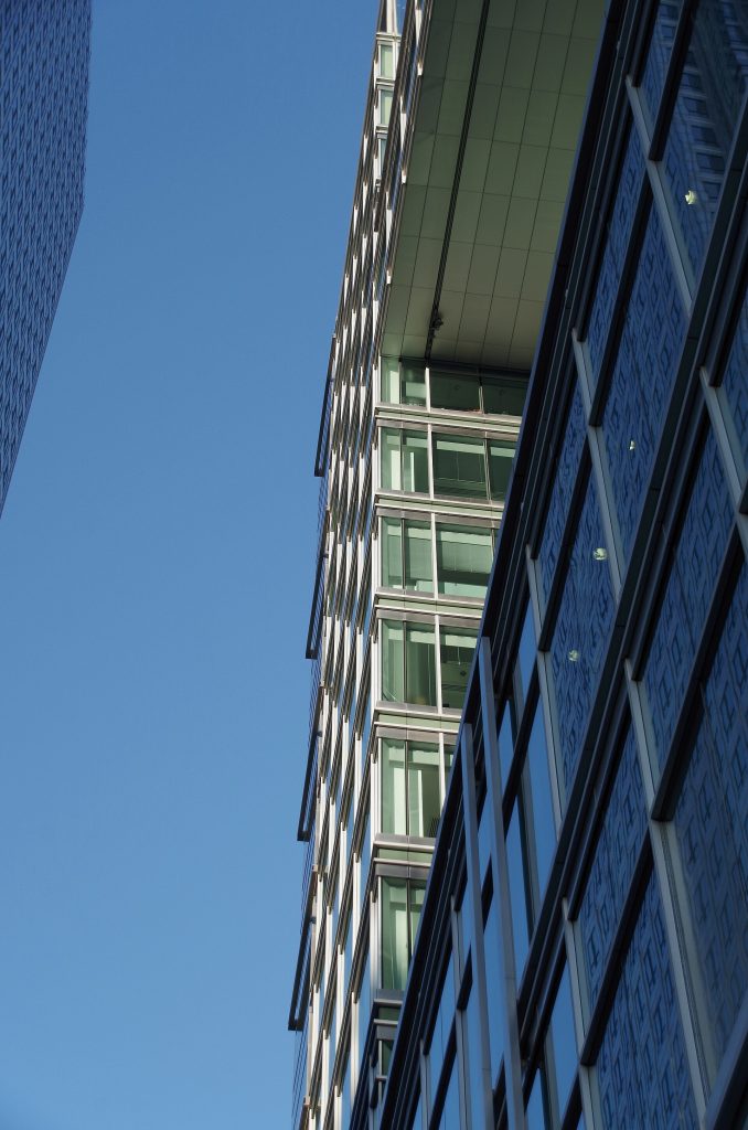 Looking up at the odd hole in the south face of 5 Canada Square on a sunny morning in Canary Wharf.