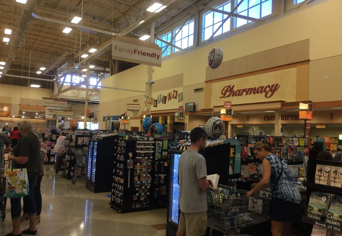 As is typical for Fred Meyer, this store has a ton of checkouts (and actually tends to staff them as need be, unlike some stores). They also almost always have some designated as "family friendly" (whatever that entails) along with the typical express lanes and self checkouts (interestingly signed here as "U-Scan Express Check-outs" rather than explicitly as self checkouts). As with so many things in this decor, the register lights are incredibly reminiscent of the QFC Fresh Fare ones, just a bit simpler and with a little bit of Fred Meyer branding. Also visible is the store's pharmacy (which has yet another sign style, this one particularly reminiscent of Kroger Script decor to my eyes) and Playland, the store's kids' play area. The clerestory (sorta) windows are also visible -- they're probably part of what makes this store feel so nice, regardless of one's opinions on the decor package.
