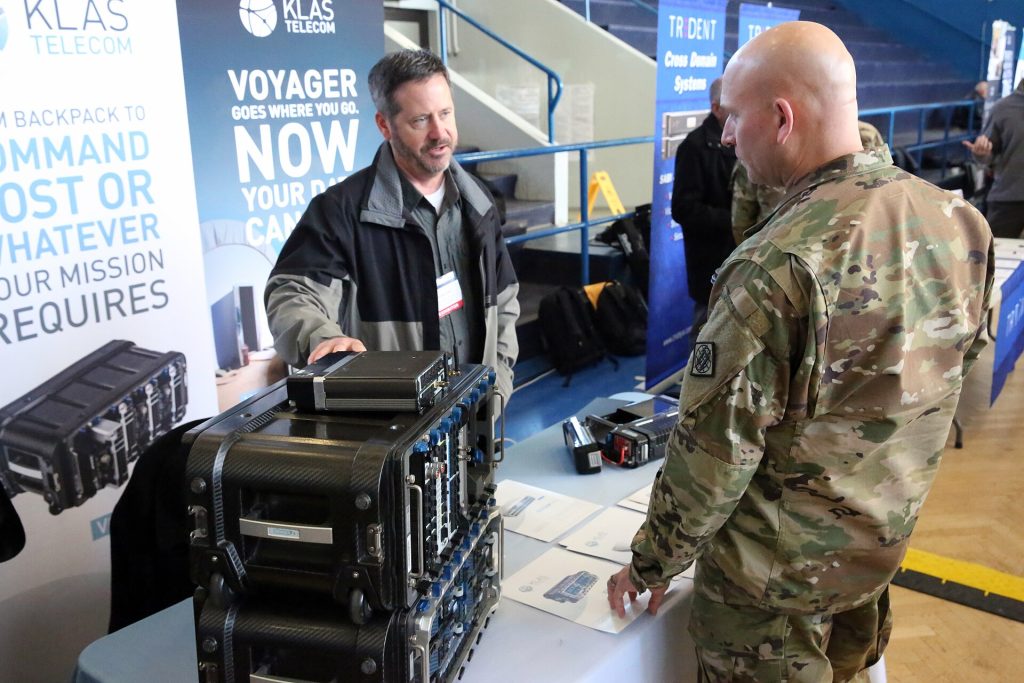 U.S. Army Command Sgt. Maj. Michael Conaty, the 2d Theater Signal Brigade senior enlisted leader, speaks with Gerhard Schultz, a vendor with Klas Telecom, at the Wiesbaden Tech Expo, Feb. 14, 2019, in Wiesbaden, Germany. (U.S. Army photo by William B. King)