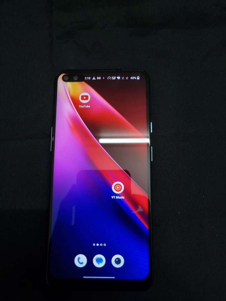 A OnePlus Nord smartphone photographed from the front, with the display turned on and showing the Android home screen. The OnePlus Nord is a mid-range Android smartphone manufactured by OnePlus. Image taken from India.