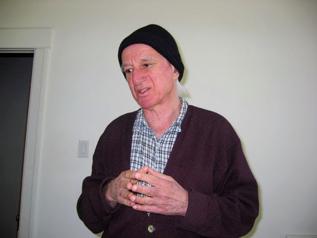 Paul J. Koosis, American Canadian Mathematician, wearing a black beanie, with hands folded.