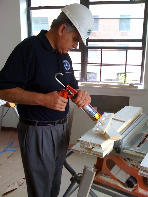 Ray LaHood, United States Secretary of Transportation, applies low-VOC adhesive with a caulking gun at the construction site of the Habitat for Humanity Atlantic Avenue Apartments, 2331 Atlantic Avenue (between Eastern Parkway and Sherlock Place) in the in the Brownsville neighborhood of the borough of Brooklyn, New York City. The United States Cabinet and other senior administrators of the U.S. government did community service on to promote the beginning of the 2009 "United We Serve" community service initiative.